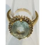 An 18ct yellow gold dress ring set with oval pale green stone to the centre, measuring 10x8mm,