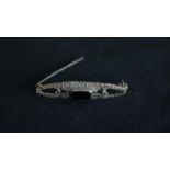 A silver and marcasite brooch, centrally set with a rectangular black stone, import marks for