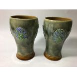 A pair of early 20th century Royal Doulton stoneware vases of tapering baluster form, decorated with