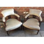 A pair of Edwardian tub chairs, both with green velour upholstery, raised on turned supports to