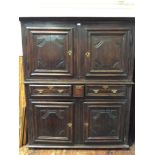 A mid 18th century continental oak cupboard, with moulded cornice above a pair of panelled doors,