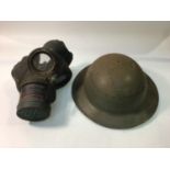 A WWII steel Brodie helmet with liner and chin strap, stamped '1941', together with a rubber gas