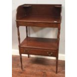 An Edwardian mahogany two tier wash stand, the under-tier with single drawer, raised on turned