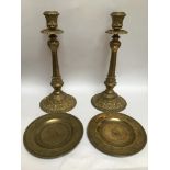 A large pair of ornately cast brass candlesticks, raised on tapering reeded supports to foliate cast