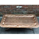 A Himalayan (Kashmir) copper tray and stand/coffee table, engraved with floral and foliate design,