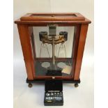 A set of Oertling Model 52.FM scales, housed in a glazed mahogany case, raised on brass feet,