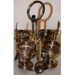 An Edwardian silver egg cruet, the revolving frame with a central ring handle, fitted four egg