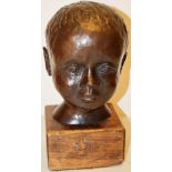 A bronze portrait bust of a child's head, the neck stamped with the Singer Foundry, mounted on an