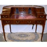 An Edwardian mahogany Carlton House style desk, the red gilt tooled leather inset writing top with