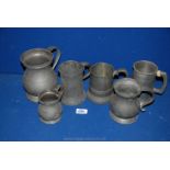 A quantity of Pewter tankards and large measure.
