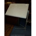 A cast iron based overbed Table, adjustable for height and slope, the top 24'' x 18'',