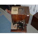 A wooden cased Willcox & Gibbs sewing machine, a little rust on the sewing plate.