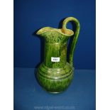A large antique Jug with streaky green glaze,