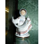 A vintage Lomonosov Eskimo figure of a young girl with the catch of the day.