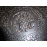 An ebonised circular Eastern occasional table the top with a nicely detailed central carved scene