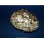 A large ornate hand painted floral egg shaped tureen with metal fret-work to handle.