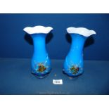 Two blue glass vases having scalloped edge and glass embossed flower to front.