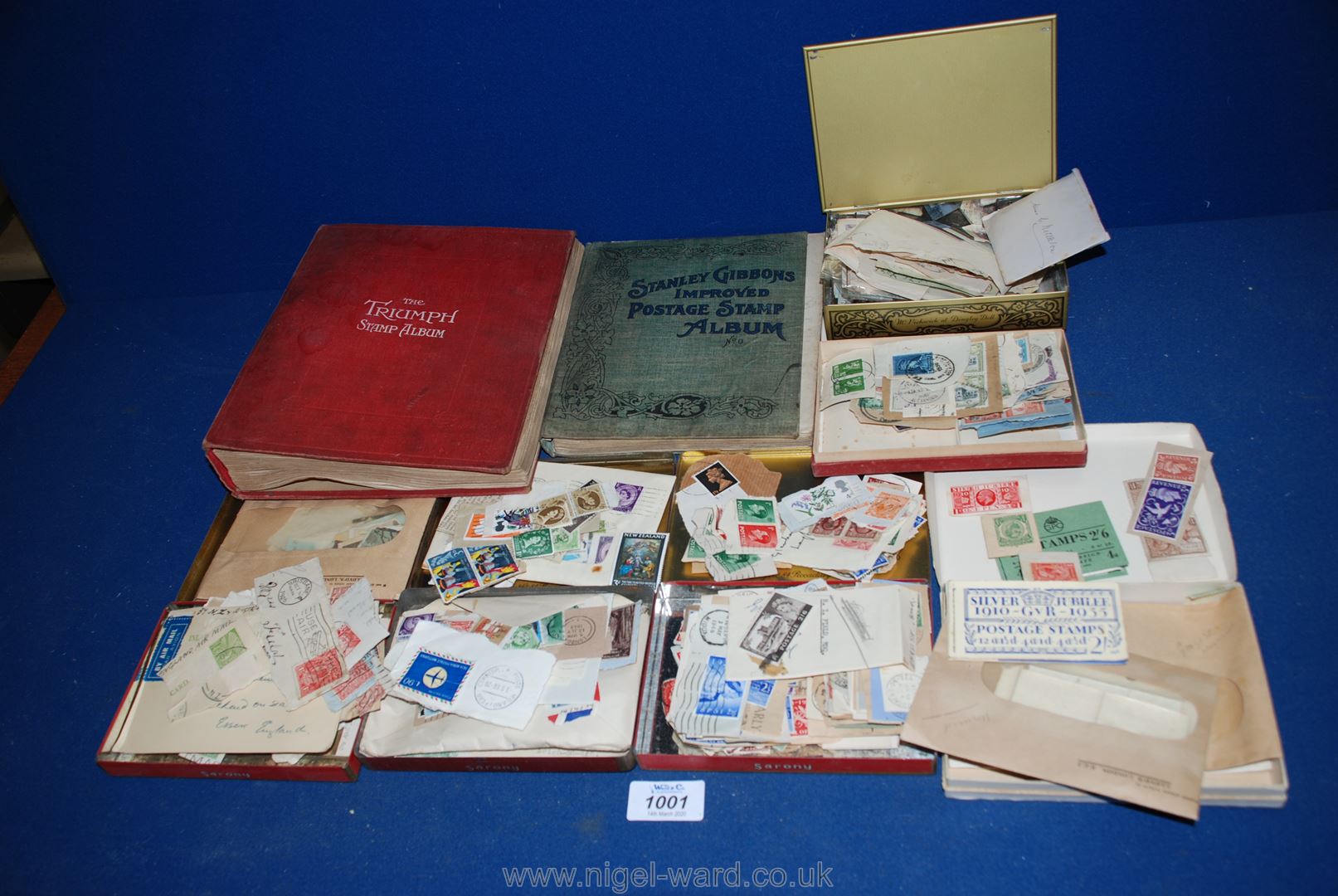 A red Triumph Stamp Album with many old English and foreign stamps together with a Stanley Gibbons