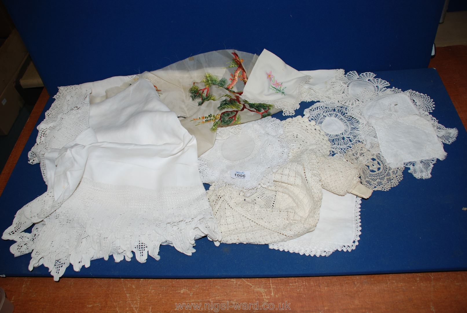 A quantity of lace and crochet including two tablecloths with lace edging and dressing table mats