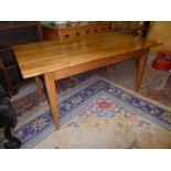 A contemporary mid Oak rectangular Dining Table standing on tapering square legs, 66'' x 36'',