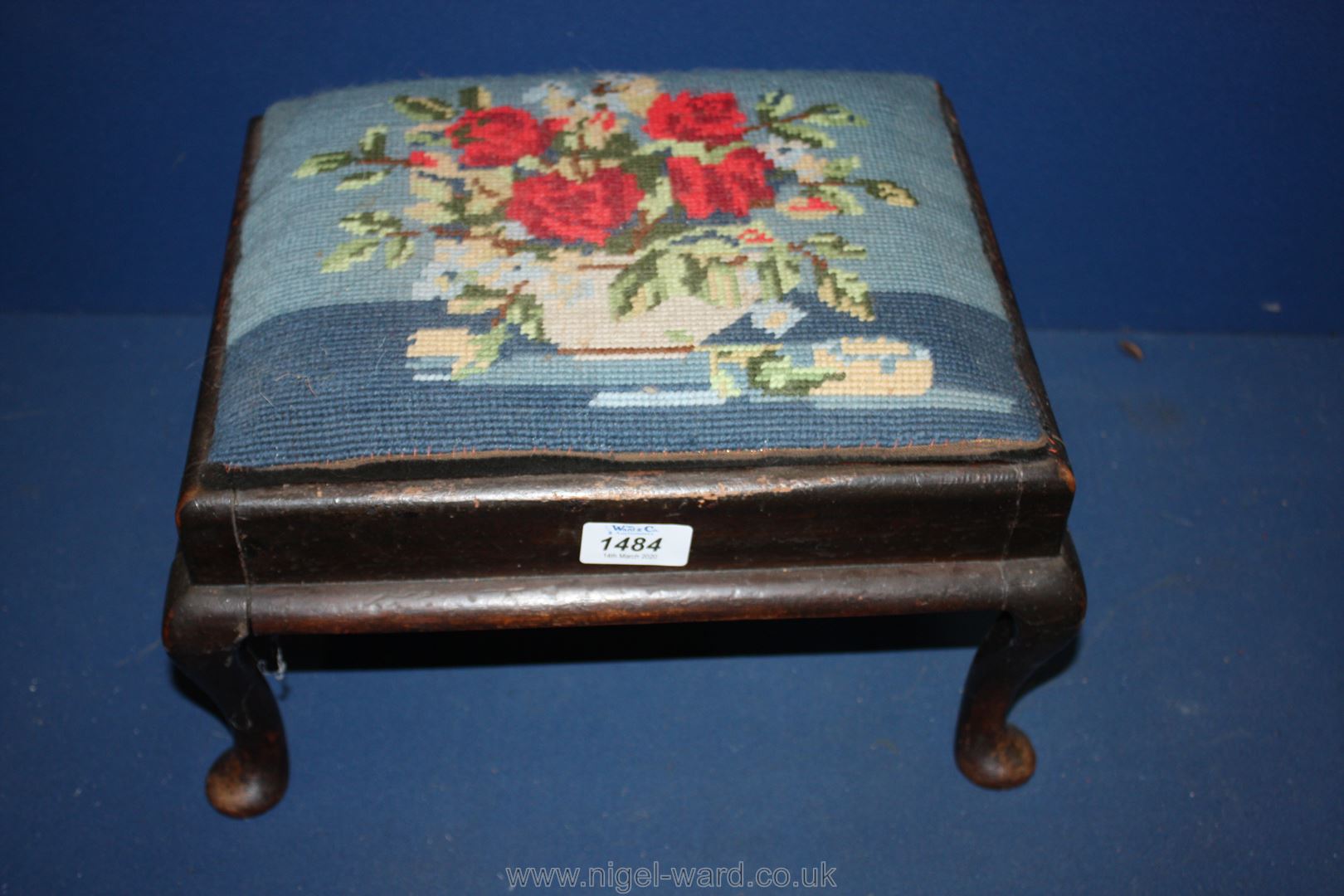 A low cabriole legged dark Mahogany framed Footstool having drop-in upholstered top decorated with