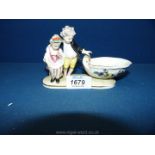 A rare Meissen figural salt, circa 1830, modelled as two children by a shell shaped bowl,