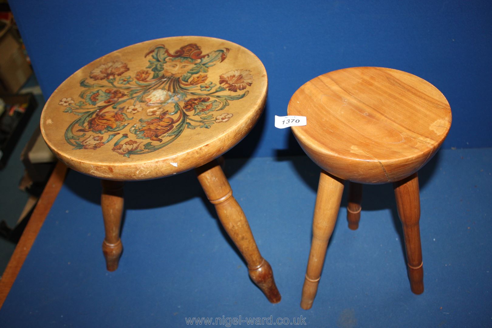 Two milking stools, one decorated with flowers.