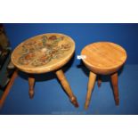 Two milking stools, one decorated with flowers.