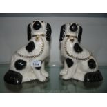 A pair of small Staffordshire style mantle Dogs with black spots and gold chains.