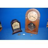 Two wooden mantle Clocks, one larger with some damage with key,