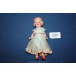 A small china doll in original dress, 6" tall.