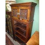 An unusual dark Oak floor standing Bookshelves having stylised foliage carved friezes,