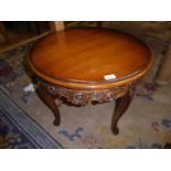 A Mahogany highly polished topped circular occasional table having carved and fretworked frieze
