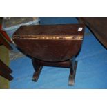 A dark stained Oak swivel top dropleaf Occasional Table having shaped slab ends,