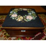 A tapestry lidded square shaped Footstool standing on bun feet.