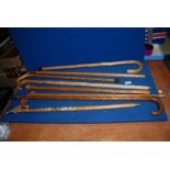 A quantity of carved walking Sticks and an Ice Pick with metal badges