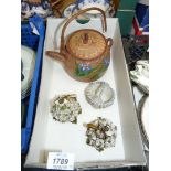 A terracotta teapot plus a pair small jugs encrusted with flowers with little cork stoppers,