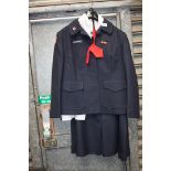 A navy blue British Red Cross jacket and skirt with two white shirts and red tie.