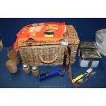 A wicker picnic hamper containing two glasses with straw holders and two small jars with straw