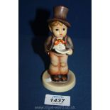 A Goebel Hummel figure of a little boy singing from sheet music.