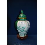A hexagonal baluster shaped lidded vase decorated with oriental bird and floral design in green and