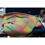 A Welsh Wool waffle weave blanket in rainbow checks, double size.
