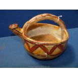 An antique berber Kabyle pottery vessel with overhead handle spout and zig-zag motif painted in