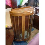A lightwood finished bow fronted glass Display Cabinet, on brief cabriole legs,