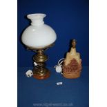 A brass oil lamp style table lamp and a pottery lamp by Bernard Rooke - chips to lamp shade.