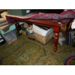 A reproduction Mahogany finished Dining Table standing on turned and lobed legs terminating in