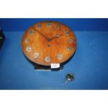 A wooden wall clock with white metal numbers, no key. 11" diameter.