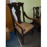 An elegant Oak framed elbow Chair having pierced top rail with carved bird wings and tail feathers,