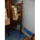 A Mahogany framed Cheval Mirror with spherical finials, reeded swept feet and brass capped castors,