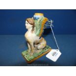 A rare Italian maiolica candlestick in the form of a seated sphinx.